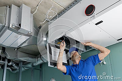 Hvac technician install ducted heat recovery ventilation system with recuperation Stock Photo