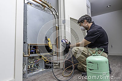 HVAC worker checking refrigerant Stock Photo
