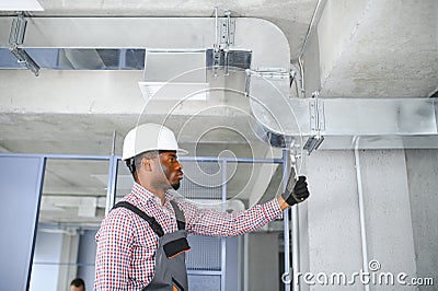 hvac african worker install ducted pipe system for ventilation and air conditioning. copy space Stock Photo