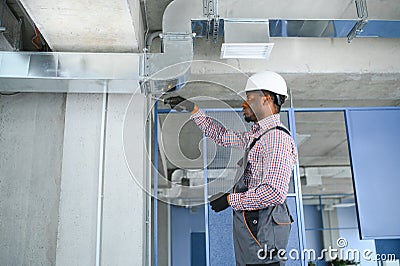 hvac african worker install ducted pipe system for ventilation and air conditioning. copy space Stock Photo
