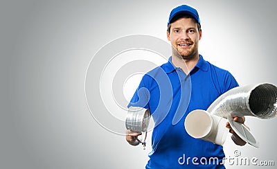 Hvac worker with ventilation system equipment in hands on gray Stock Photo