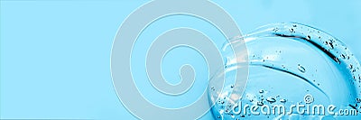 Hyaluronic acid cosmetic gel. Gel texture with bubbles on a blue background. Transparent smear of gel Banner Stock Photo