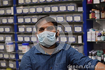 Hyderabad, Telangana, India. june-29-2020: shopkeeper running his business while wearing a mask, corona pandemic concept, medical Editorial Stock Photo