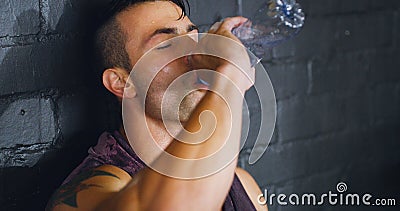 Hydrate, rest, repair, repeat. a young man drinking water during a break from his workout at a gym. Stock Photo