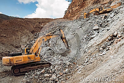 Hydraulic crusher and track type excavator backhoe machinery working on site demolition and construction site Stock Photo