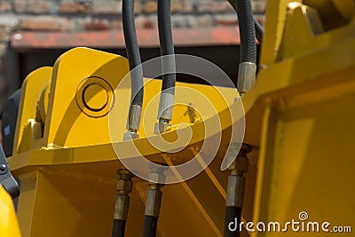 Hydraulic hoses and other mechanisms of yellow road machinery close-up Stock Photo