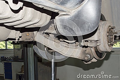 The hydraulic rack supports the rear suspension arm during disassembly Stock Photo