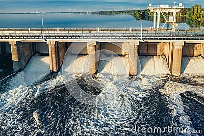 Hydroelectric dam or hydro power station at water reservoir, aerial view from drone. Draining water through gate Stock Photo