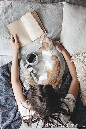 Hygge concept with cat, book and coffee in the bed Stock Photo