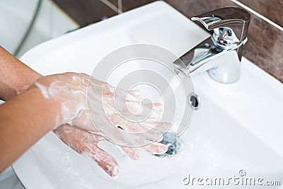 Hygiene concept. Washing hands with soap under the faucet with water Stock Photo