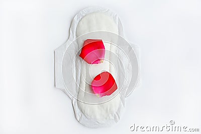 Hygiene during menstruation in women. Sanitary napkin with red rose petals on a white background Stock Photo