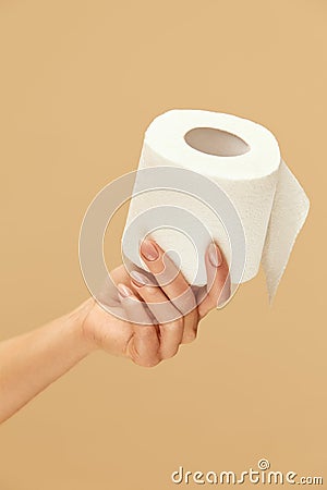 Hygiene. Toilet Paper Roll In Female Hand On Beige Background. Stop Panic About COVID Outbreak Stock Photo