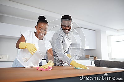 A hygienic home is a healthy home. a young couple cleaning the kitchen counter at home. Stock Photo