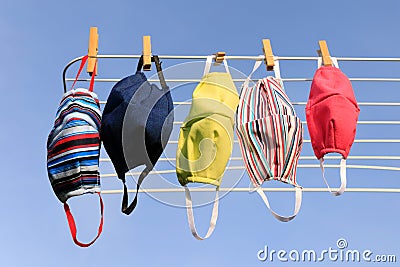 Hygienic mask hanging on the rack outdoor after being washed for cleanness and hygiene during Covid-19 virus outbreak. Drying mask Stock Photo
