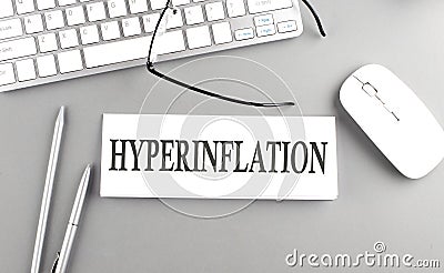 HYPERINFLATION text on paper with keyboard on grey background Stock Photo