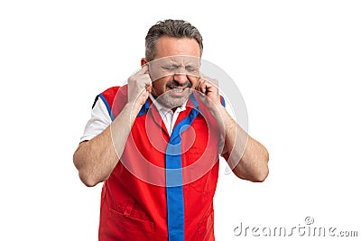Hypermarket employee holding fingers inside ears as loud noise concept Stock Photo