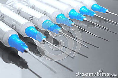 Hypodermic syringe. Syringes with blue needles on a red background. Medical Injectors. Stock Photo