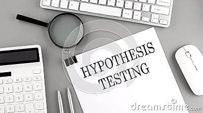 Hypothesis testing written on paper with office tools and keyboard on the grey background Stock Photo