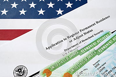 I-485 Application to register permanent residence or adjust status form and green card from dv-lottery lies on United States flag Editorial Stock Photo