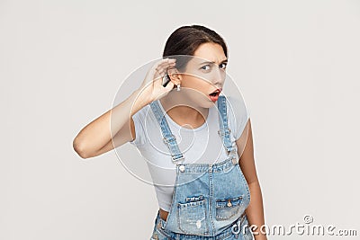 I can not hear you. Beautiful young adult lady. Studio shot, gray background Stock Photo