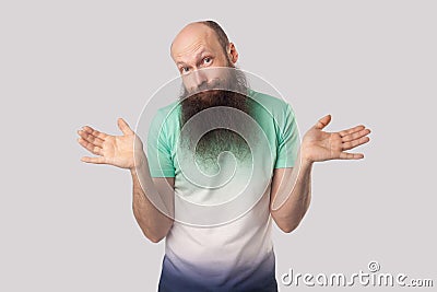 I don`t know. Portrait of puzzled or confused middle aged bald man with long beard standing with raised arms and looking at camer Stock Photo