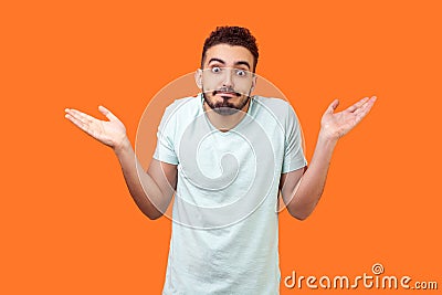 I don`t know, who cares. Portrait of confused clueless brunette man making no idea gesture. isolated on orange background Stock Photo