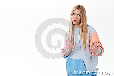I dont like it. Portrait of disappointed, unsatisfied blonde girl stay away, raising hands in stop, rejection, cringing Stock Photo