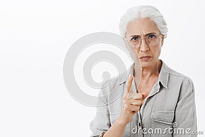 I forbid you. Portrait of strict and serious disappointed granny with white hair in glasses frowning with mad expression Stock Photo