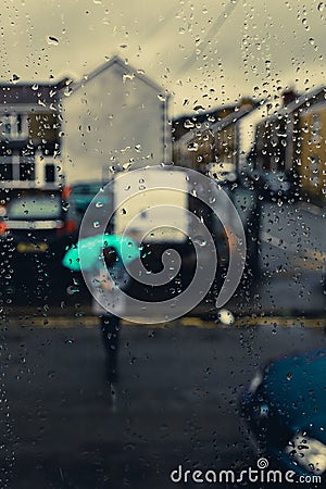 Girl with an umbrella in the background and water drops in focus / Water drops background and a girl with umbrella Stock Photo