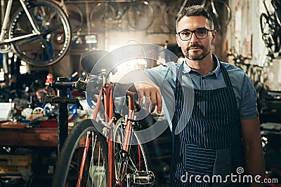 I know whats best for your bike. Portrait of a mature man working in a bicycle repair shop. Stock Photo