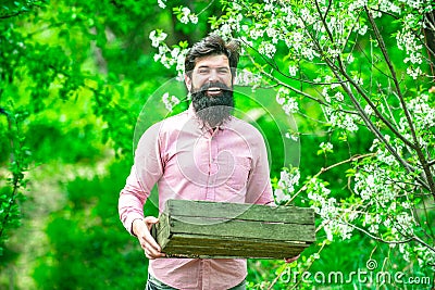 I like spending time on farm. Spring. Become organic farmer. Farmer on farmland. Farmer hold box. Become organic farmer. Stock Photo