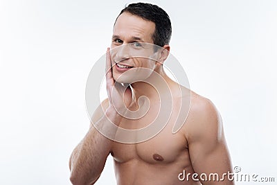 Happy handsome man touching his cheek Stock Photo