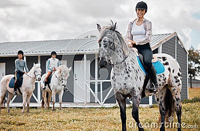 I love horse riding. Cropped portrait of an attractive young woman horse riding on a farm with her friends in the Stock Photo