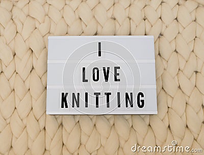 I LOVE KNITTING word on lightbox on knit background. Cozy compozition. Knit WOOL background. Stock Photo