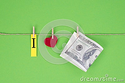 I love money concept. Close up view photo of one hundred bucks with little red heart attached on rope isolated over bright green Stock Photo