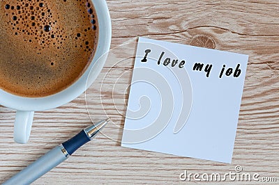 I love my job motivation inscription on peace of paper at workplace near morning coffee cup. With empty space for text Stock Photo