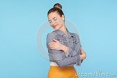 I love myself. Portrait of attractive self-confident woman with hair bun embracing herself with expression of pleasure self-love Stock Photo