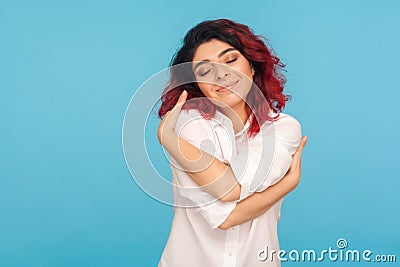 I love myself. Portrait of beautiful narcissistic woman with fancy red hair embracing herself Stock Photo