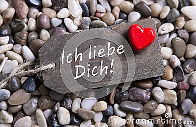 I love you card with german text and a red heart on a wooden sign. Stock Photo