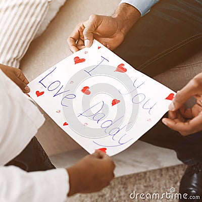 I love you, daddy. Little girl giving postcard to father Stock Photo