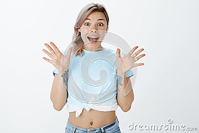 I am so lucky, cannot believe. Portrait of surprised and excited good-looking woman in cropped t-shirt with tattooed Stock Photo