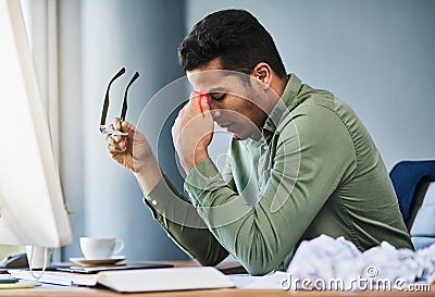 I need to take something for this splitting headache. a uncomfortable young businessman holding his forehead with his Stock Photo