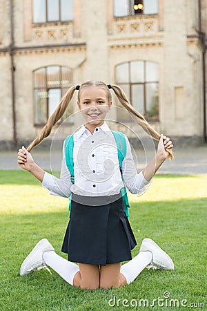 I never learn. Carefree student. Smiling pupil sit on grass. Have fun. Happy kid relaxing outdoors. Cheerful schoolgirl Stock Photo