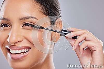 I prefer longer and fuller lashes. an attractive young woman standing alone in the studio and applying mascara. Stock Photo