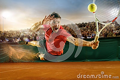 The one jumping player, caucasian fit man, playing tennis on the earthen court with spectators Stock Photo