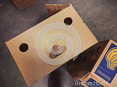 I see faces. Cardboard box in a warehouse. The holes in the box give the impression the cardboard container has a face. Editorial Stock Photo