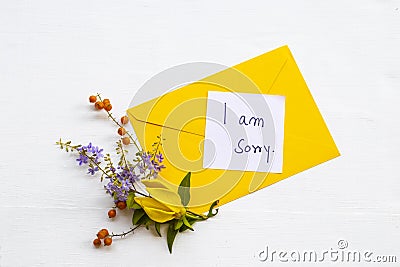 I am sorry message card handwriting with yellow envelope, yellow flower ylang ylang and little purple Stock Photo