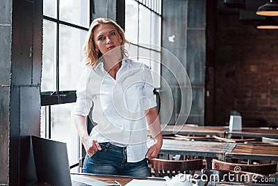 I think I done my job for today. Businesswoman with curly blonde hair indoors in cafe at daytime Stock Photo