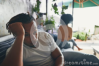 I think shes being totally petty. a young man looking upset after an argument with his partner at home. Stock Photo