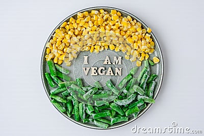 I AM VEGAN text in plate. Veganism, vegetarian healthy lifestyle. Healthy eating vegan, green beans yellow corn Stock Photo